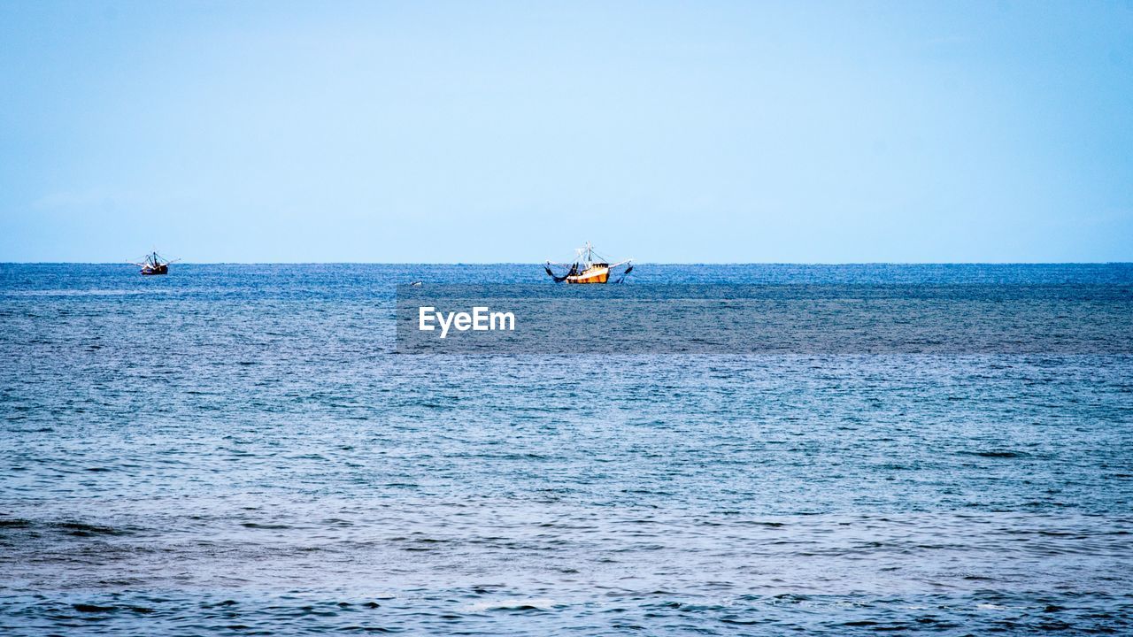 BOAT IN SEA AGAINST CLEAR SKY