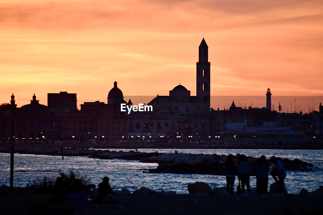 SILHOUETTE OF BUILDINGS AT WATERFRONT