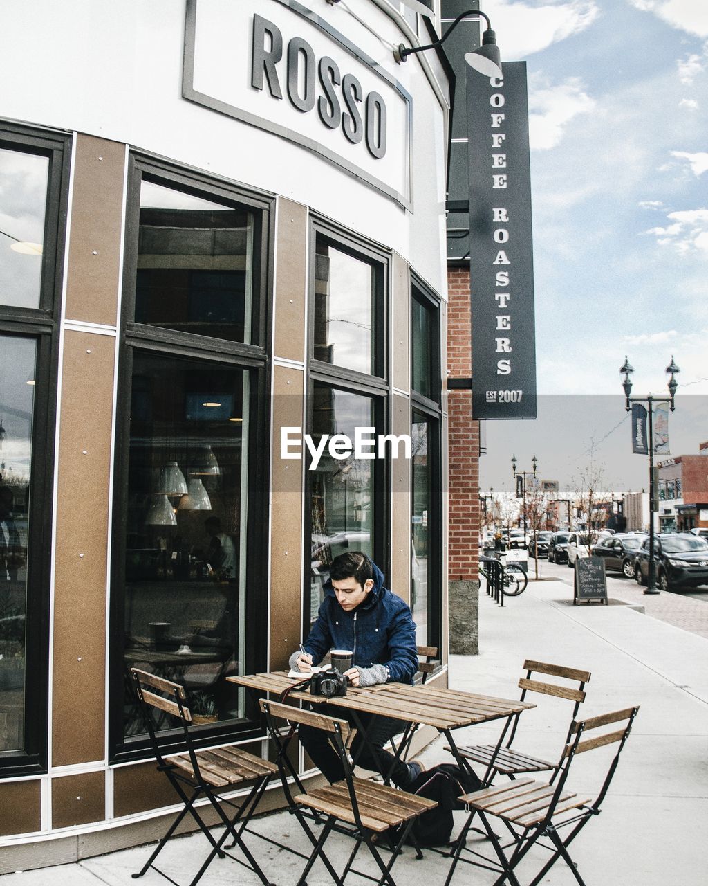 PORTRAIT OF MAN SITTING ON STORE