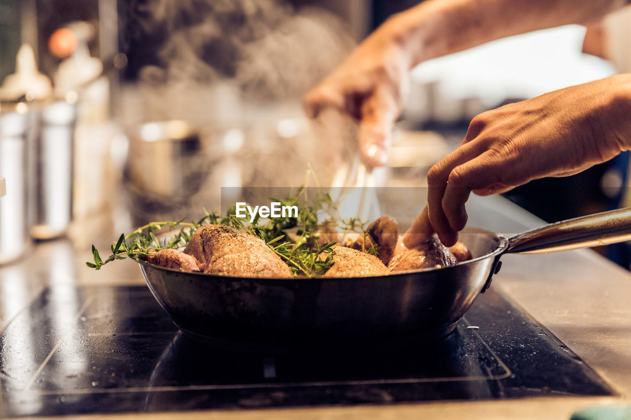 Cropped hands preparing food in kitchen