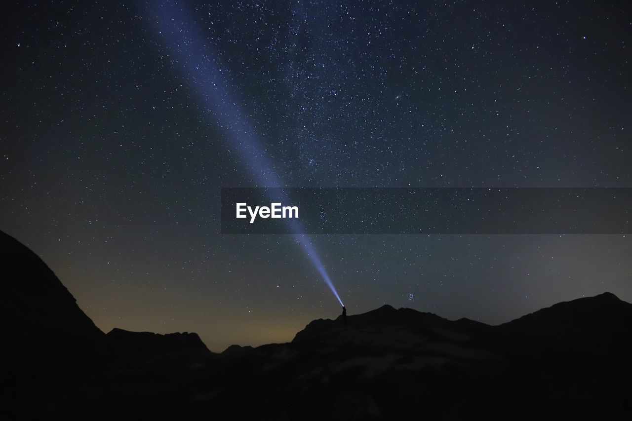 Low angle view of silhouette mountain against sky at night