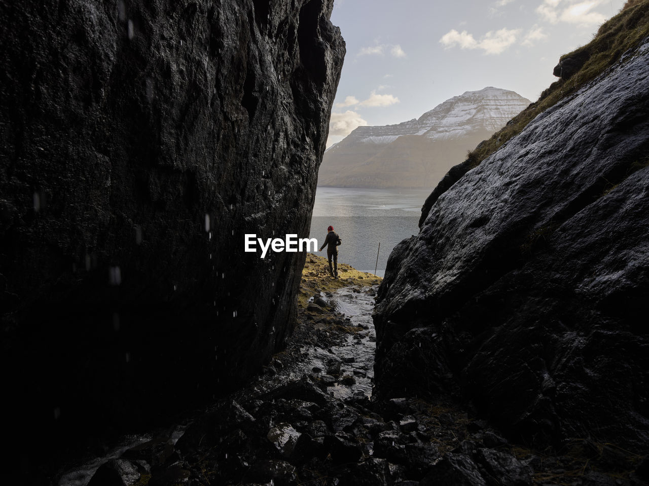 Woman hiking along oceanside trail in the faroe islands