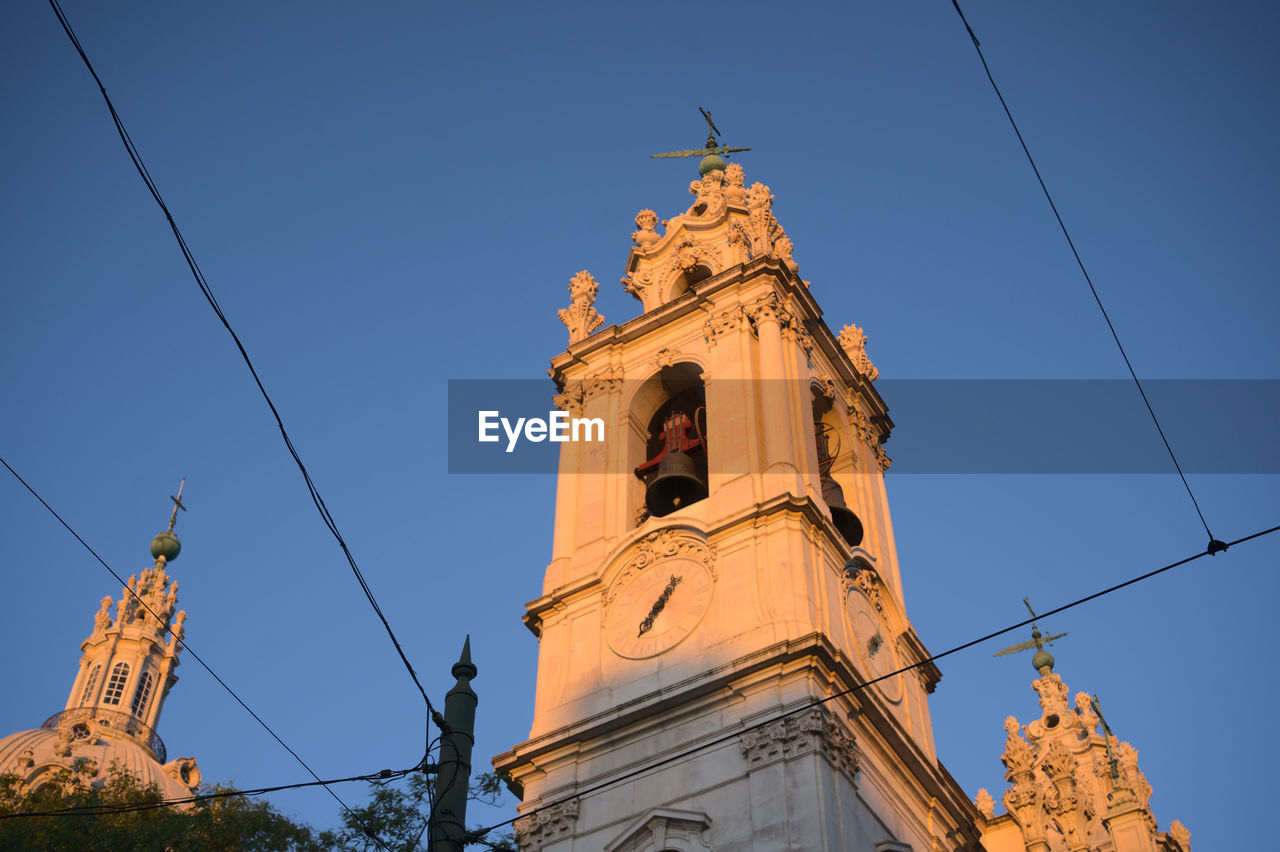 Tramway cables and towers of the basilica of estrella in lisbon, lapa, portugal during early morning