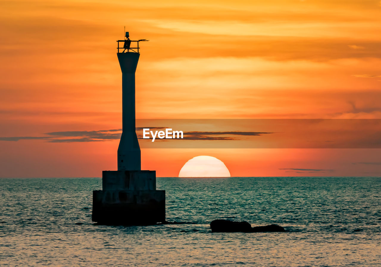 Silhouette of lighthouse at sunset