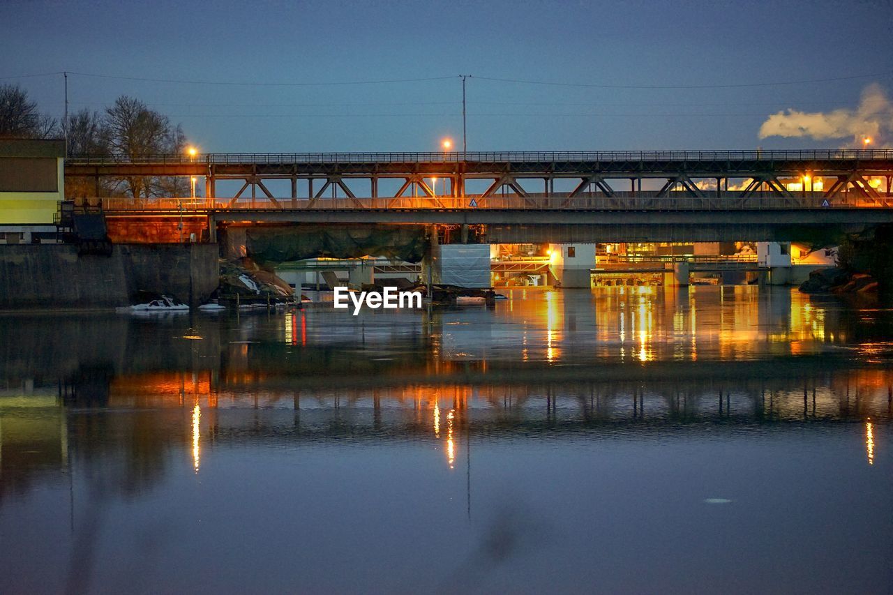 BRIDGE OVER RIVER AGAINST SKY AT NIGHT