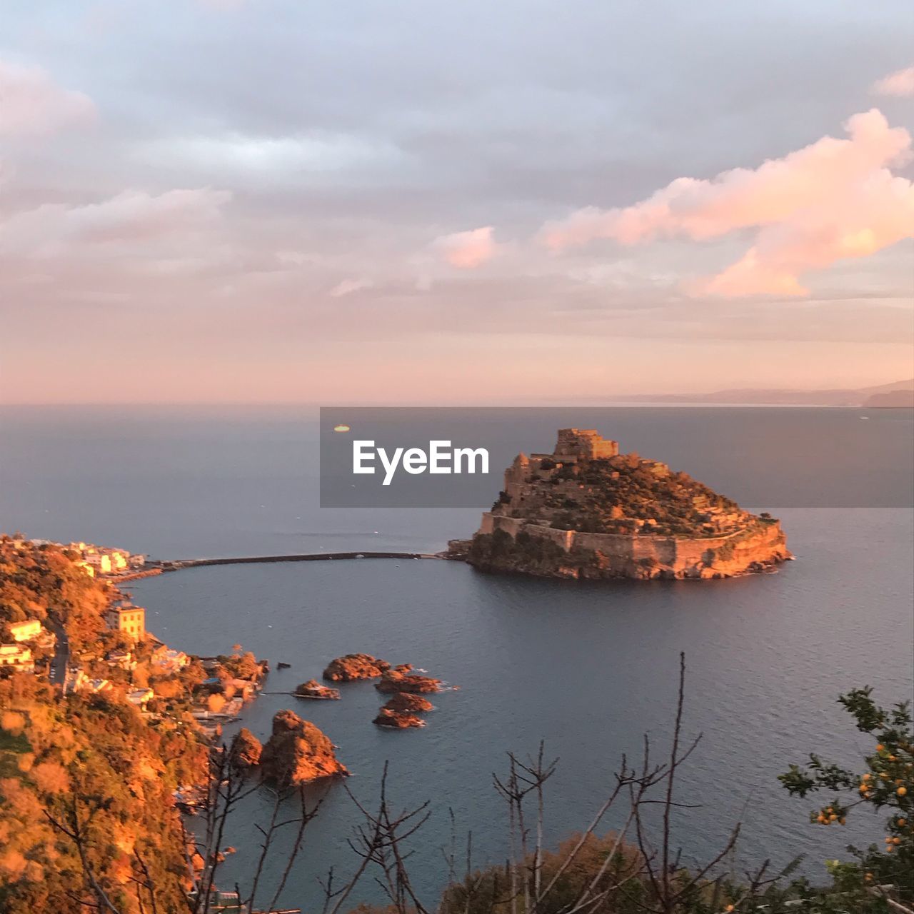 ROCKS BY SEA AGAINST SKY AT SUNSET