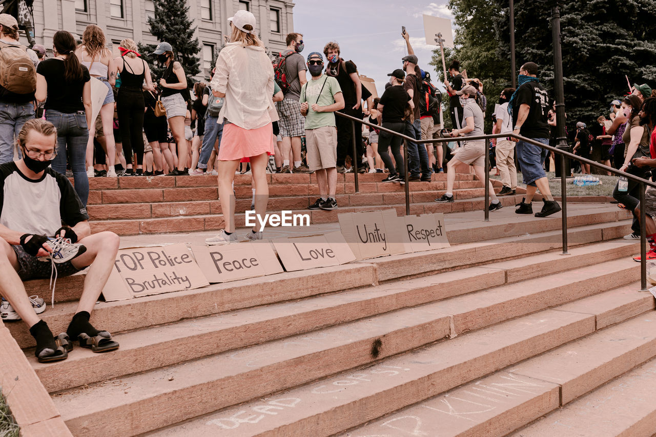 GROUP OF PEOPLE ON STAIRCASE BY THE WALL