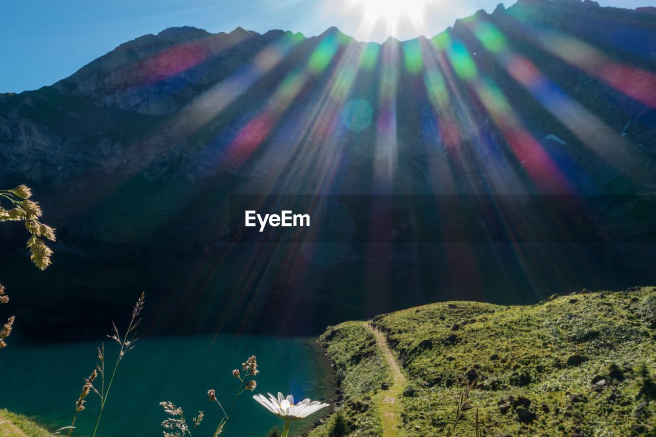 Lake against mountain on sunny day