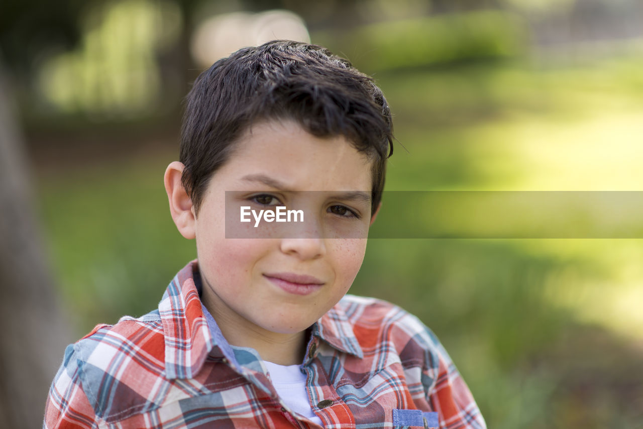 Portrait of boy sitting at park