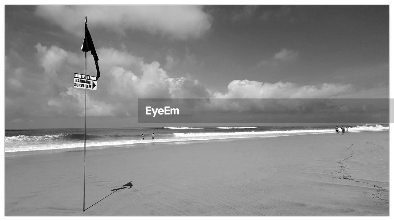 Scenic view of beach against cloudy sky