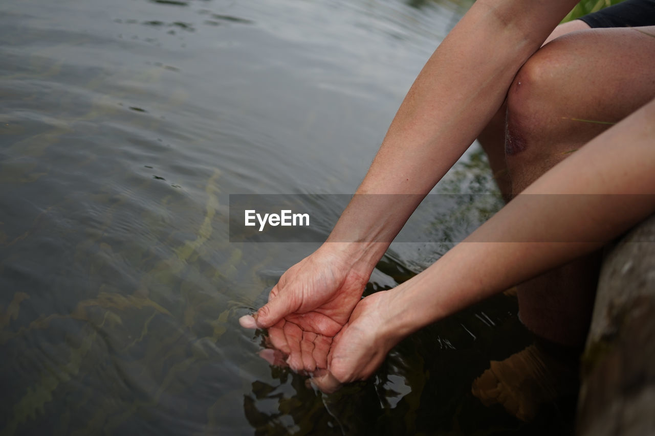 Hands dipping in river water