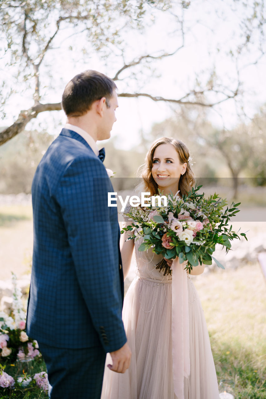 portrait of bride and bridegroom holding bouquet