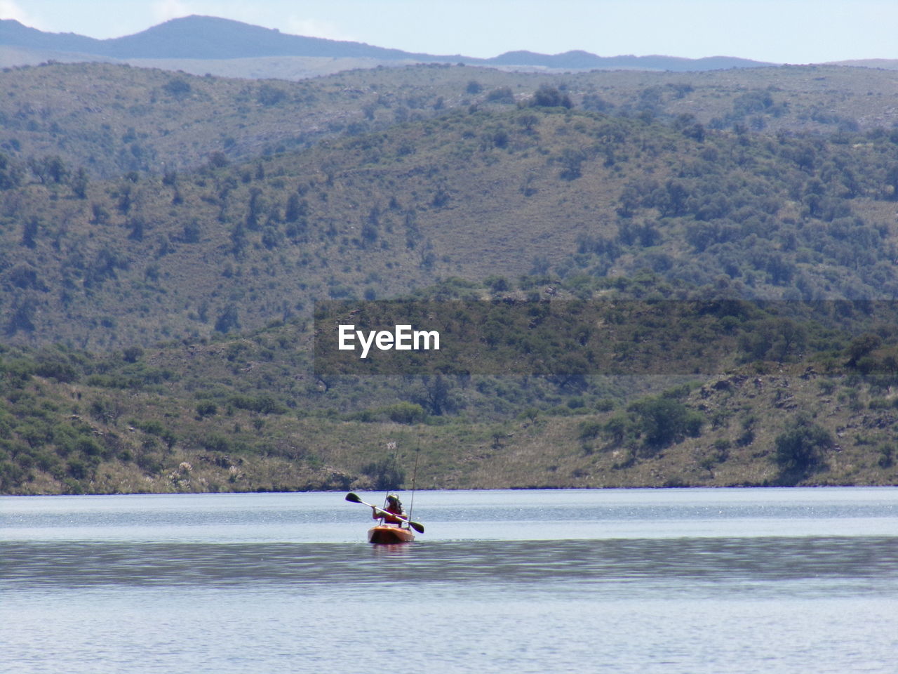 BOAT SAILING ON LAKE BY MOUNTAIN AGAINST SKY