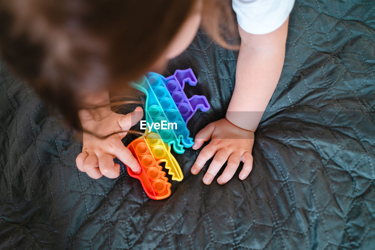 High angle view of girl playing with toy