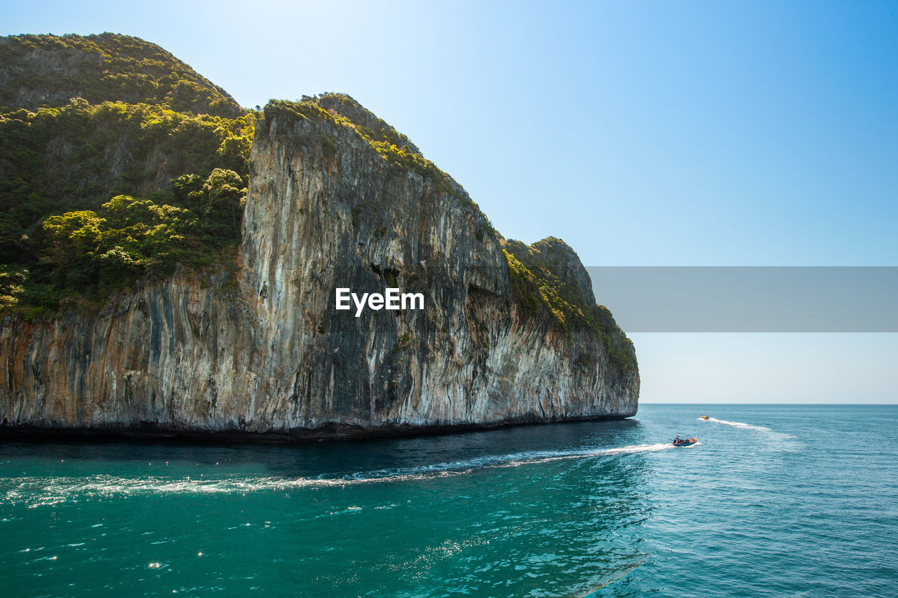 ROCK FORMATION IN SEA AGAINST CLEAR BLUE SKY