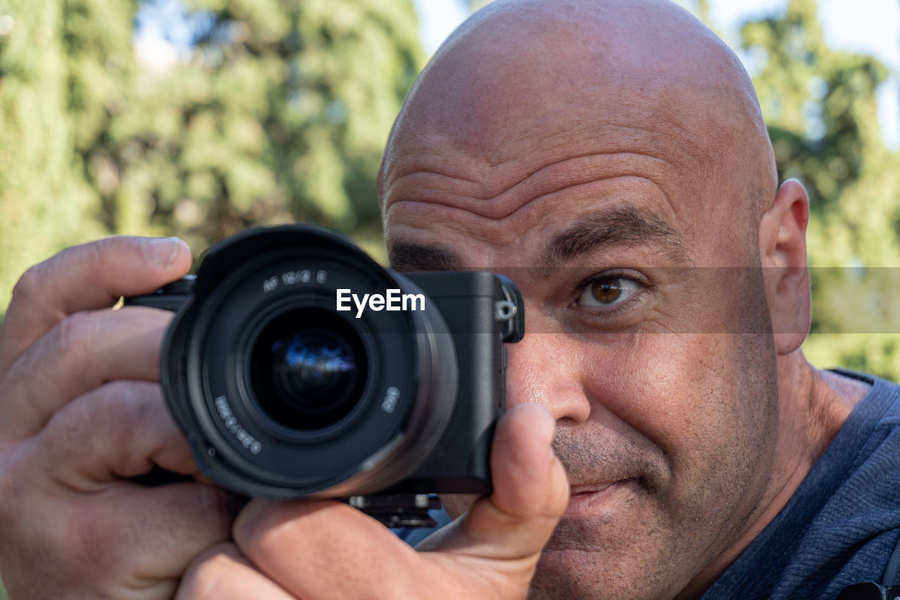 Close-up, man takes pictures with a dslr camera, outdoors.