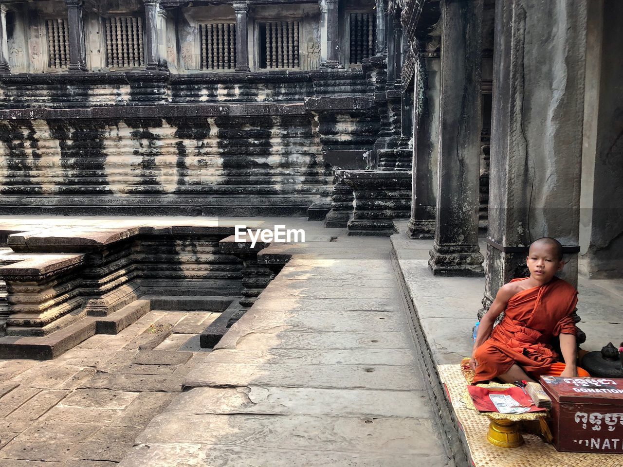 FULL LENGTH OF MAN SITTING OUTSIDE TEMPLE