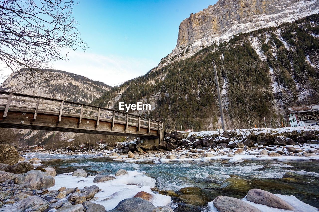 Bridge over river against sky during winter