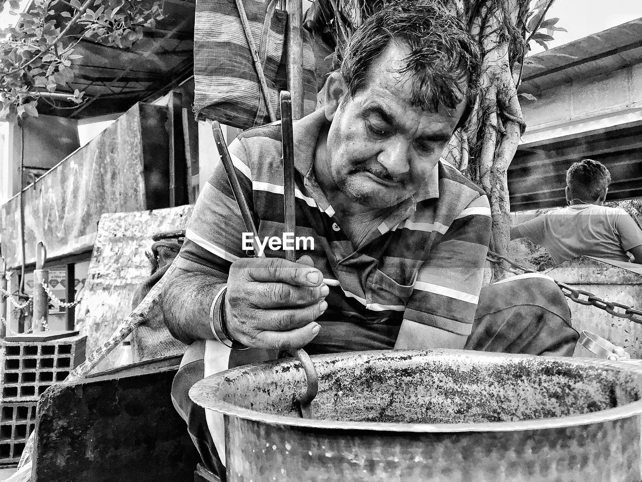 Vendor carrying utensil with serving tongs at market stall