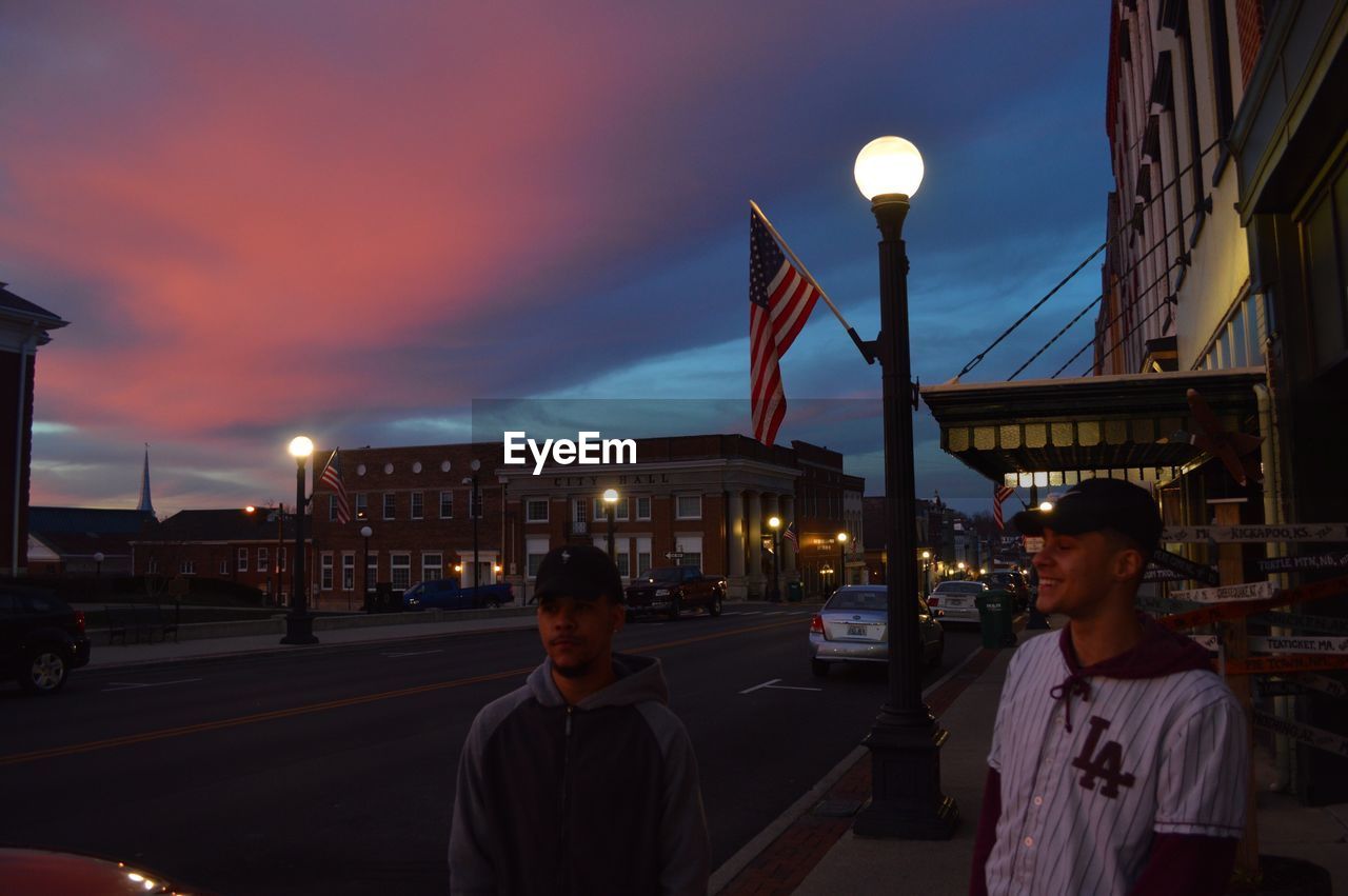 PEOPLE IN CITY AGAINST SKY AT DUSK