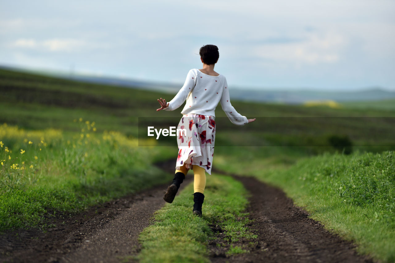 Rear view of man walking on road