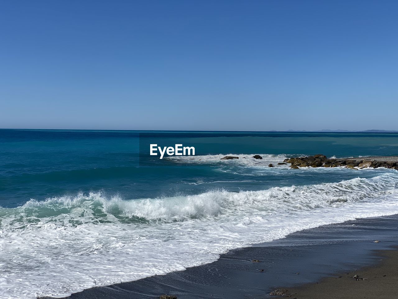 sea, water, beach, land, body of water, sky, wave, scenics - nature, motion, beauty in nature, shore, ocean, horizon over water, horizon, wind wave, nature, water sports, clear sky, surfing, sports, sand, blue, vacation, coast, day, tranquility, tranquil scene, travel destinations, outdoors, idyllic, travel, sunny, copy space, coastline, water's edge, tourism, sunlight, non-urban scene, environment