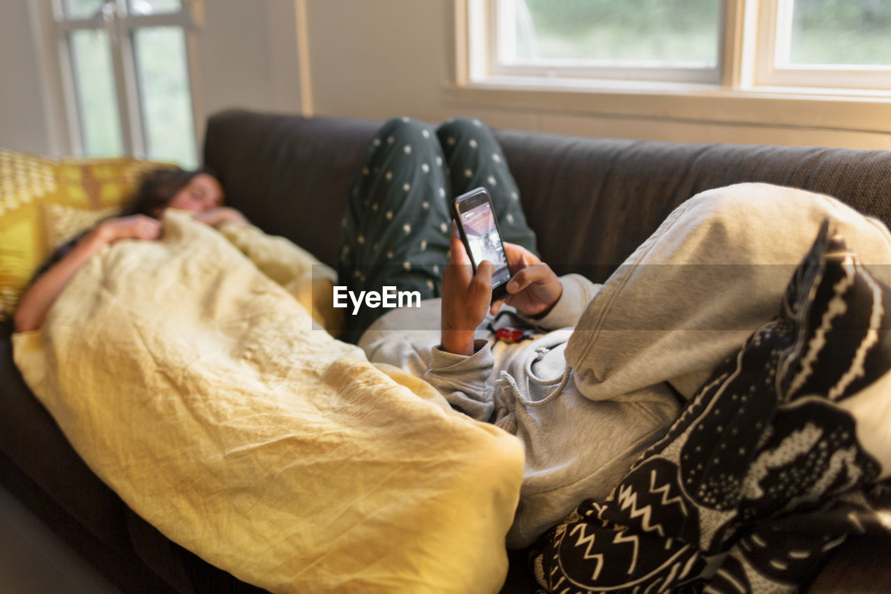 Woman on sofa using cell phone