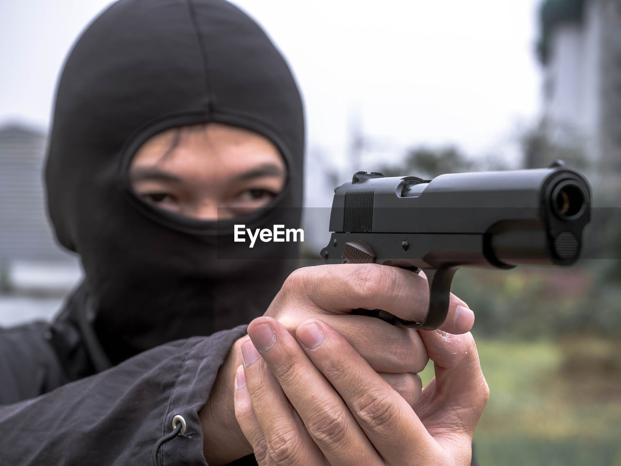 Man aiming gun outdoors