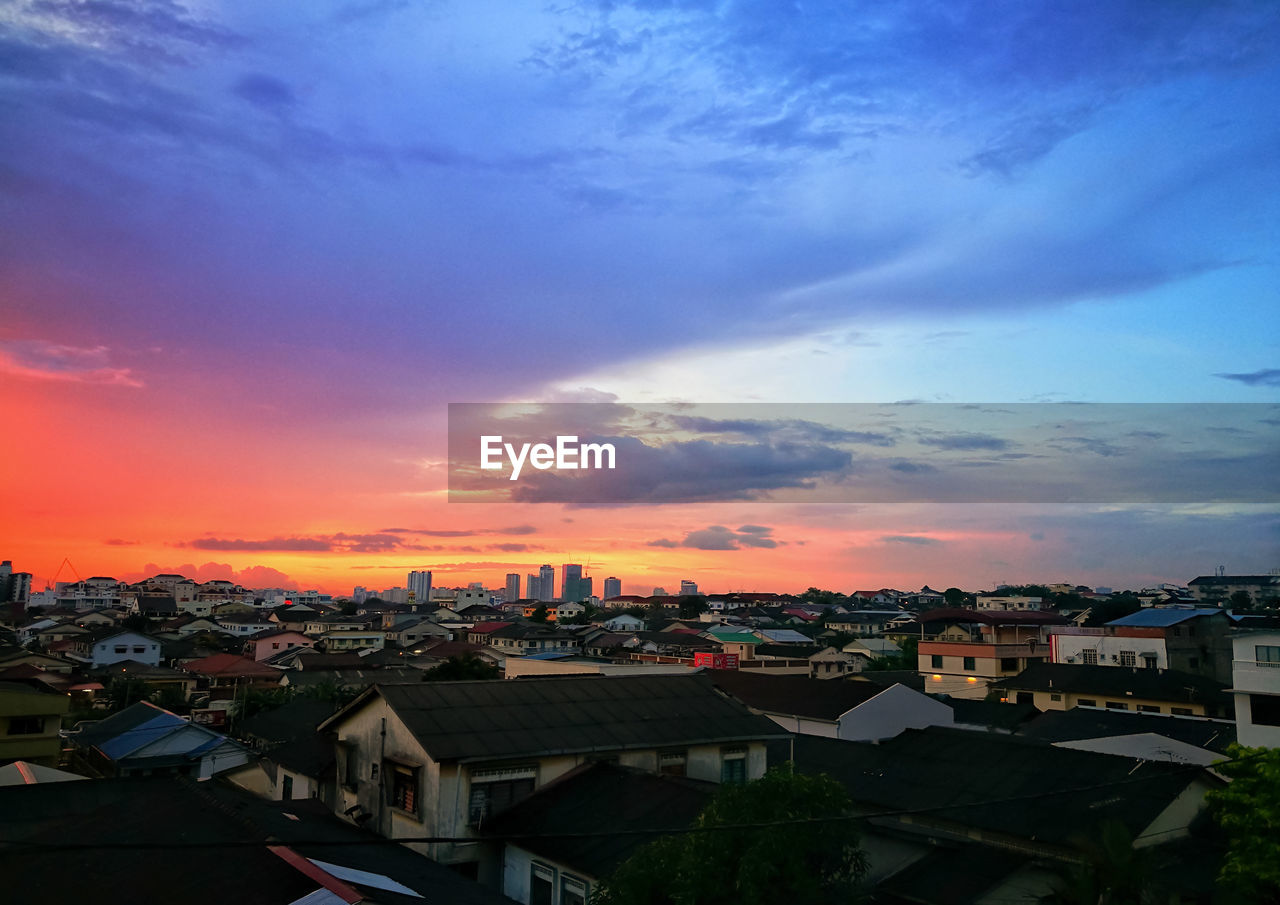 HIGH ANGLE VIEW OF TOWNSCAPE AGAINST ORANGE SKY