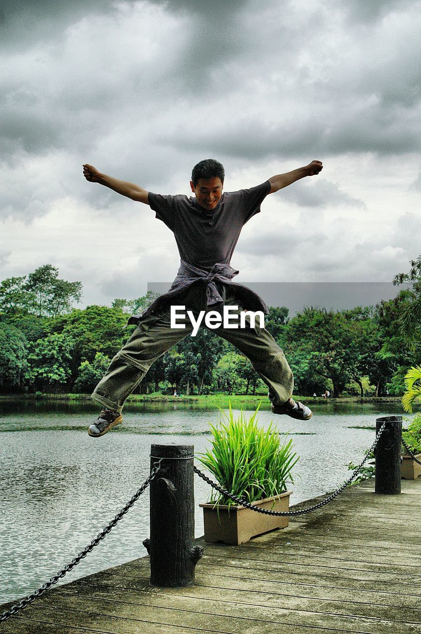 FULL LENGTH OF MAN JUMPING AGAINST SKY