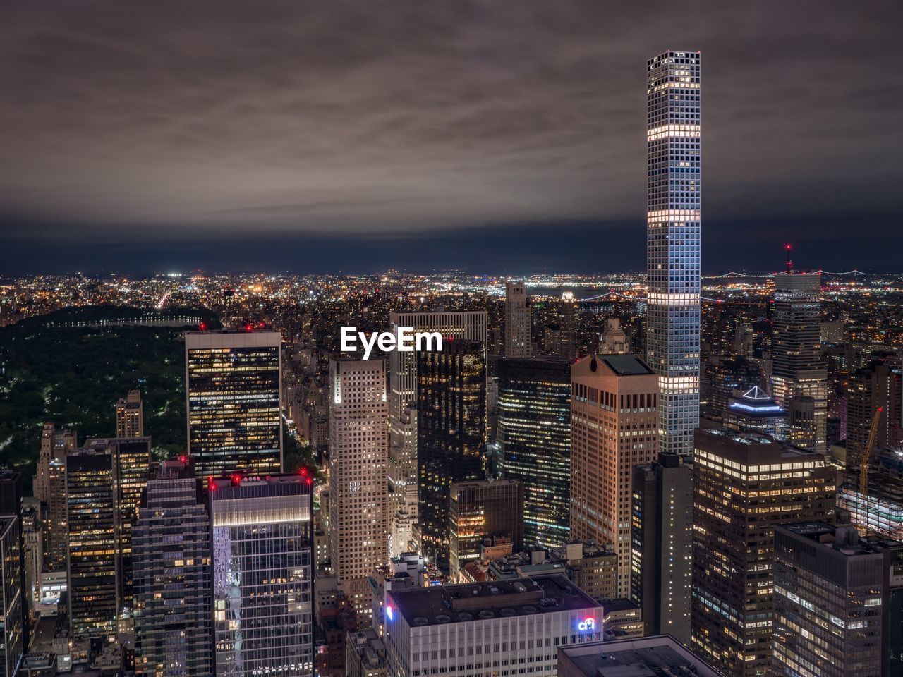 Aerial view of illuminated buildings in city against sky