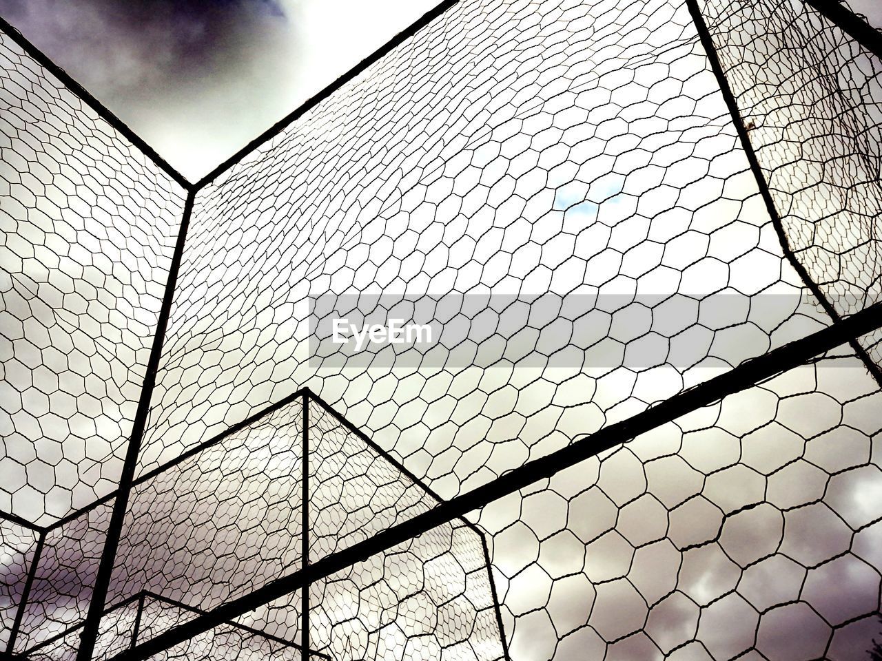 pattern, sky, line, chainlink fence, net, fence, no people, low angle view, built structure, architecture, chain-link fencing, wire fencing, cloud, nature, day, metal, outdoors, sunlight, backgrounds, circle, full frame, security, mesh, building exterior, outdoor structure, wire, protection, shape, wire mesh