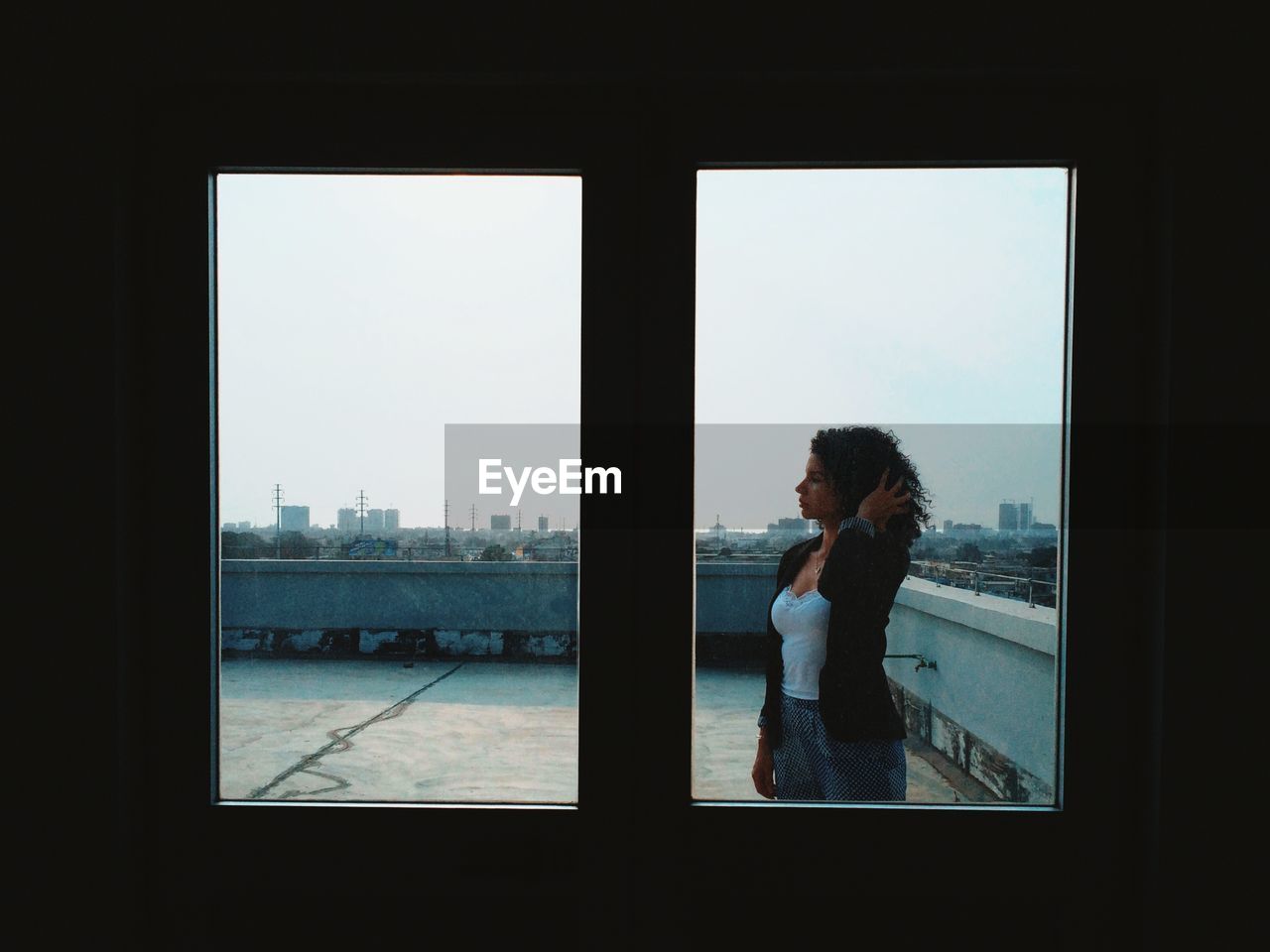 Womman standing by window on rooftop