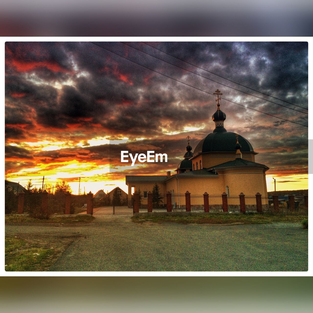 SILHOUETTE OF BUILDING AGAINST CLOUDY SKY DURING SUNSET