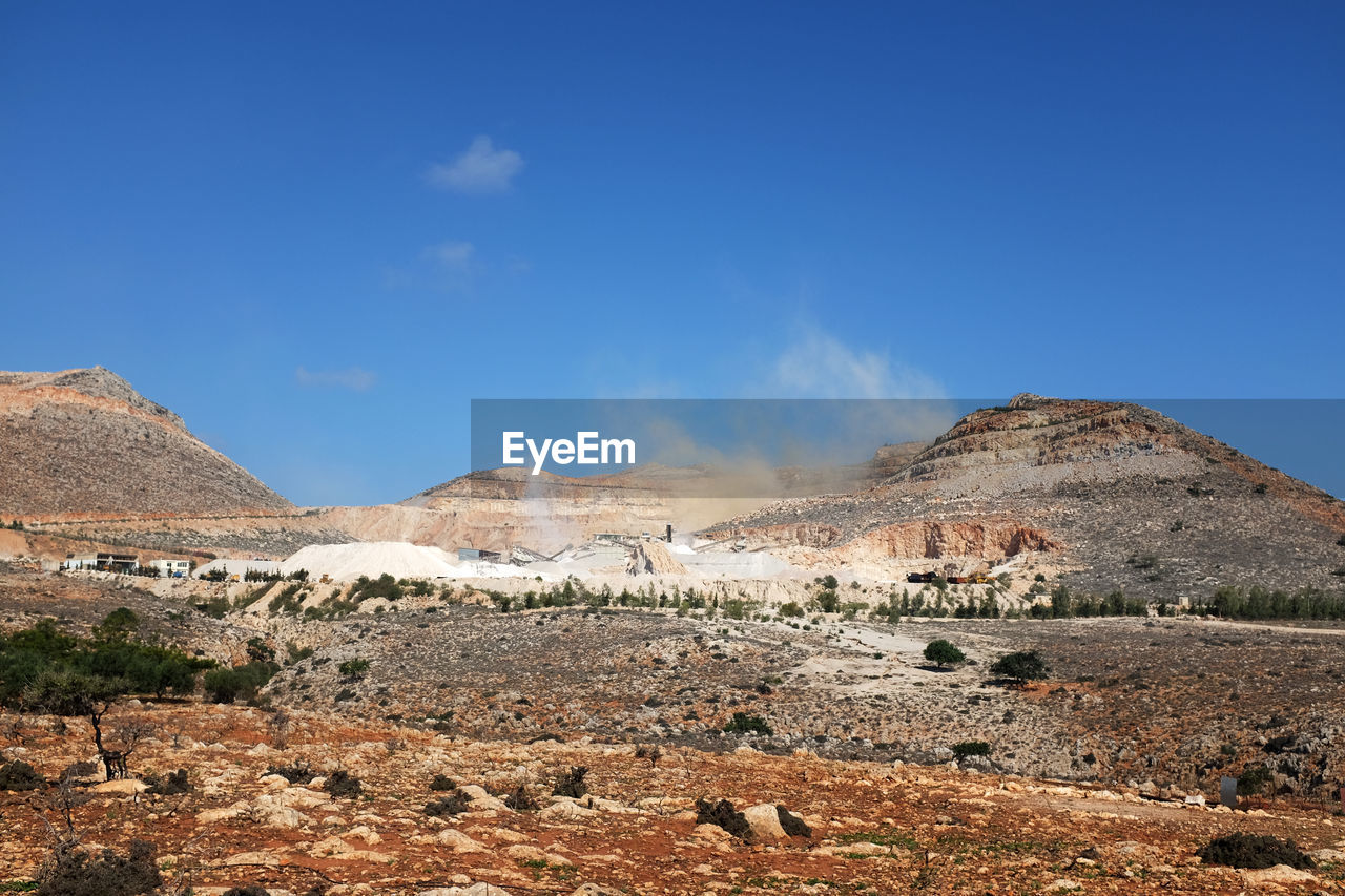 Scenic view of desert against blue sky