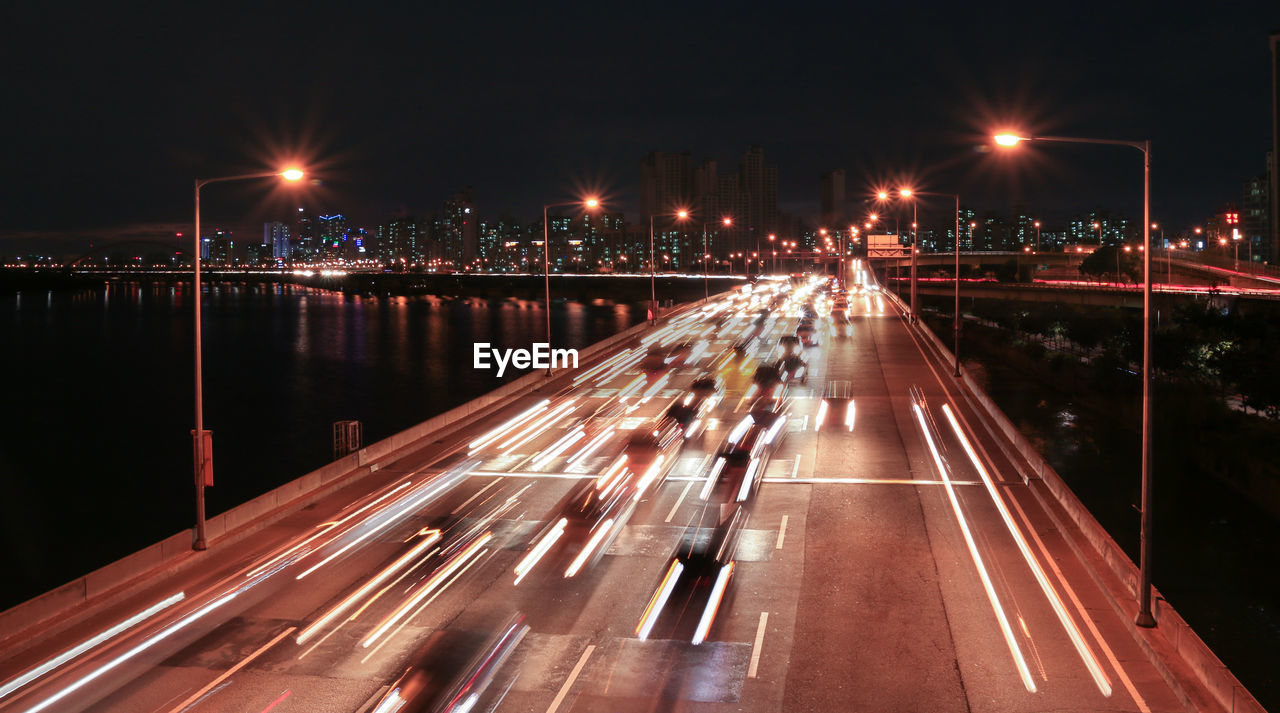 LIGHT TRAILS ON STREET AT NIGHT