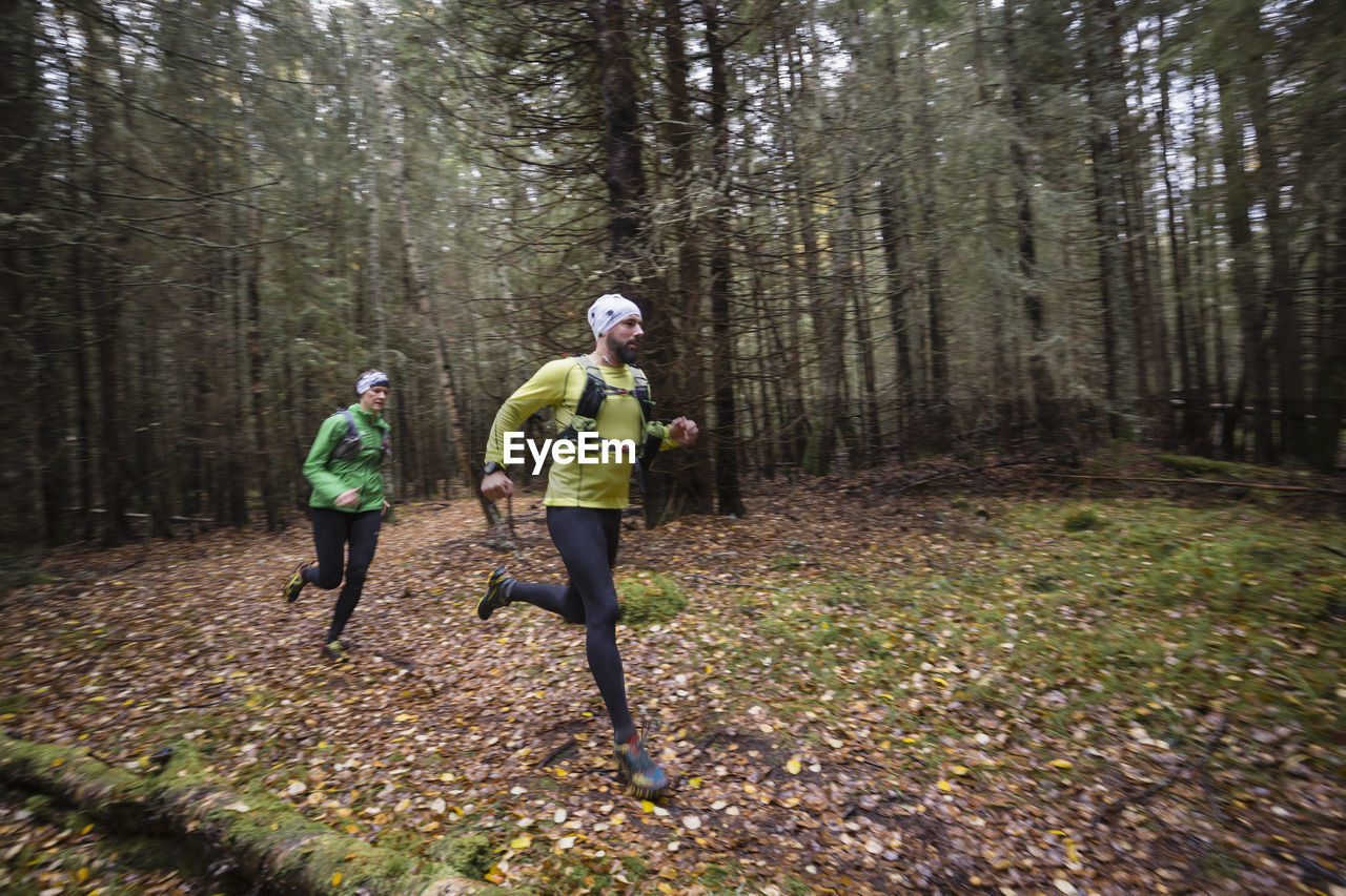 Man and woman running in forest