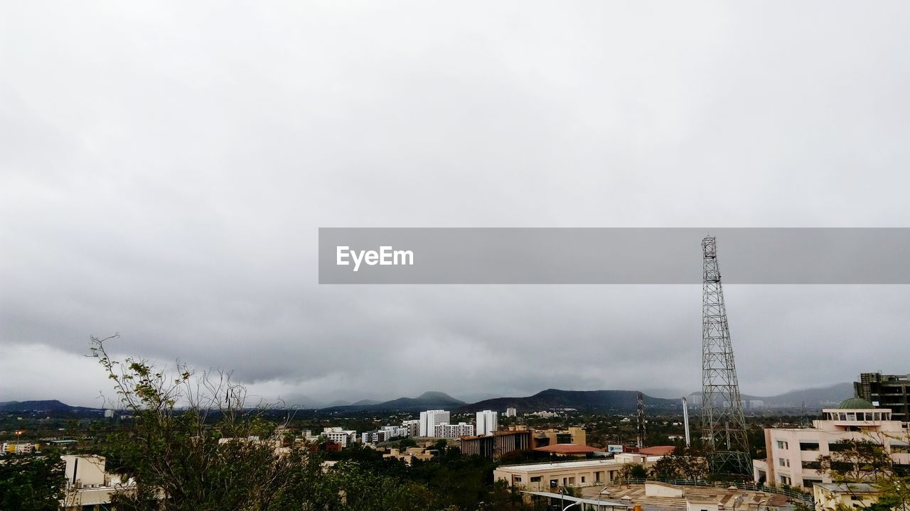 Houses in town against cloudy sky