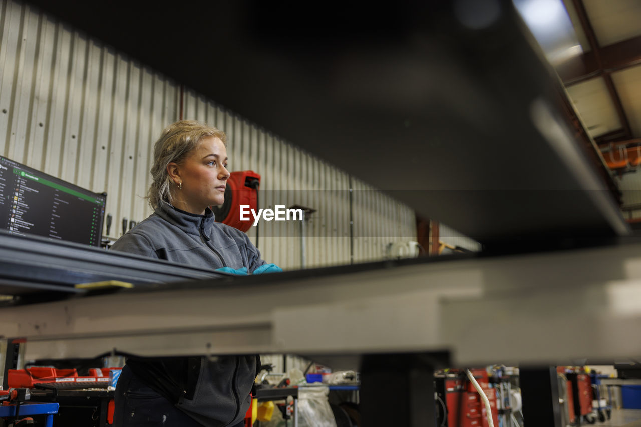 Young female industrial worker working in factory