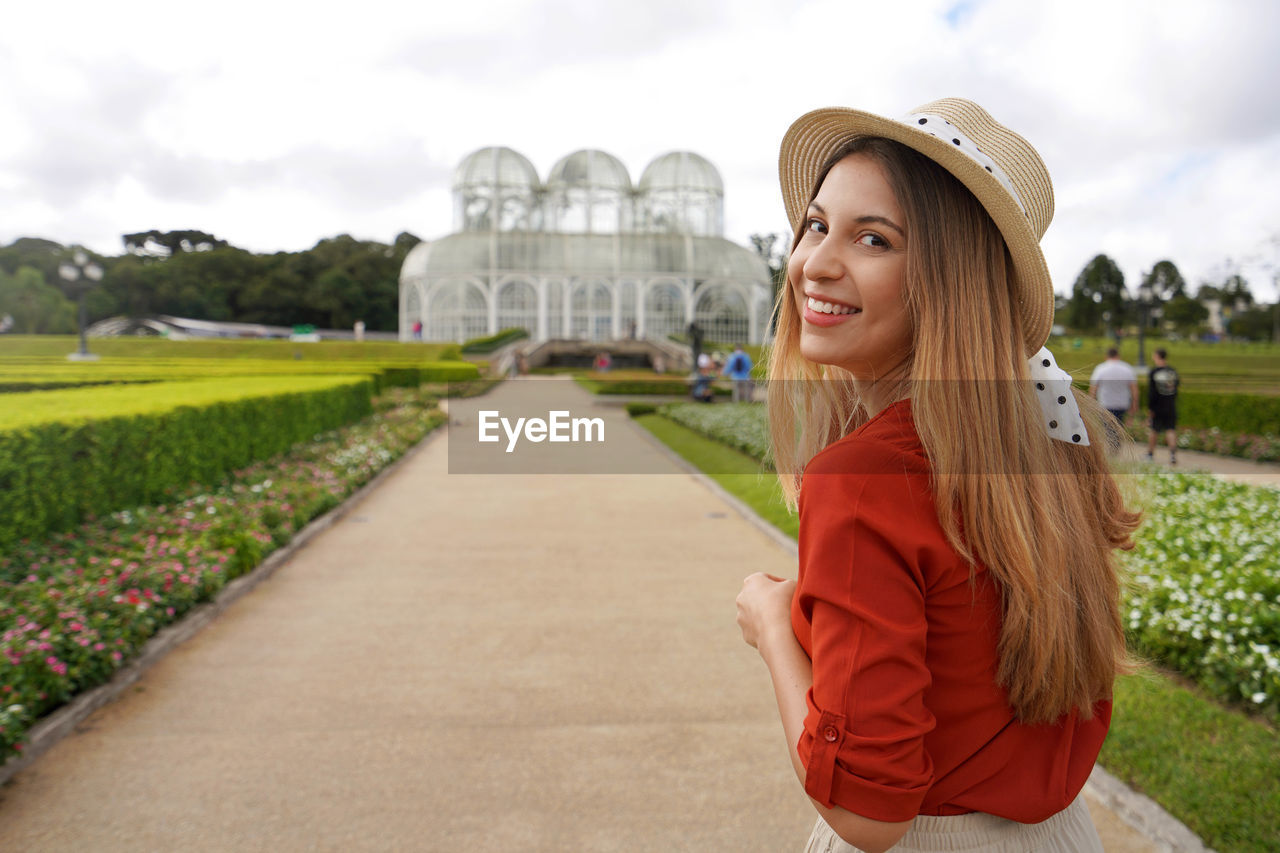 Woman with hat walking in the botanical garden of curitiba,  parana, brazil