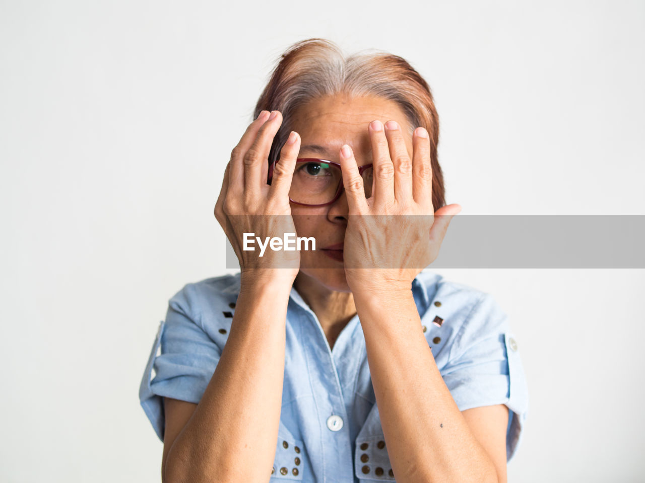 Portrait of serious senior woman against white background