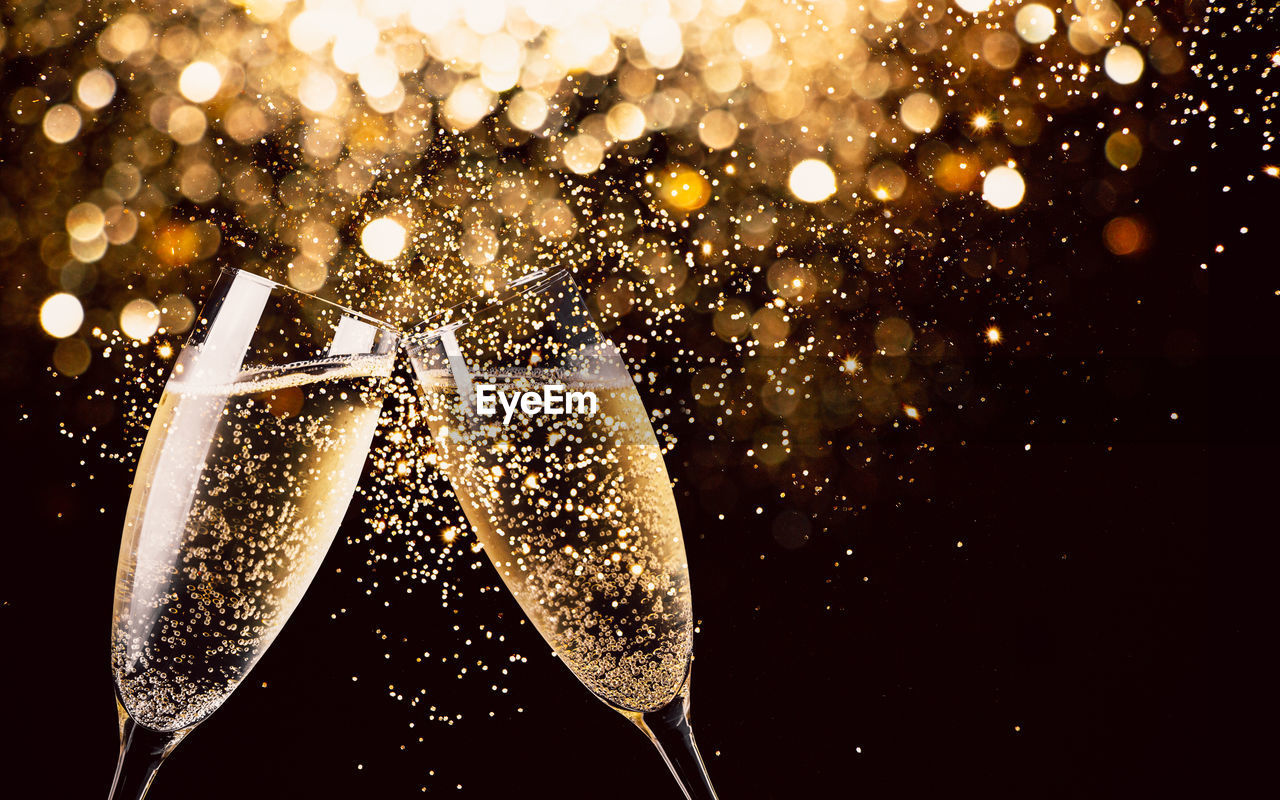 Close-up of champagne flutes against black background