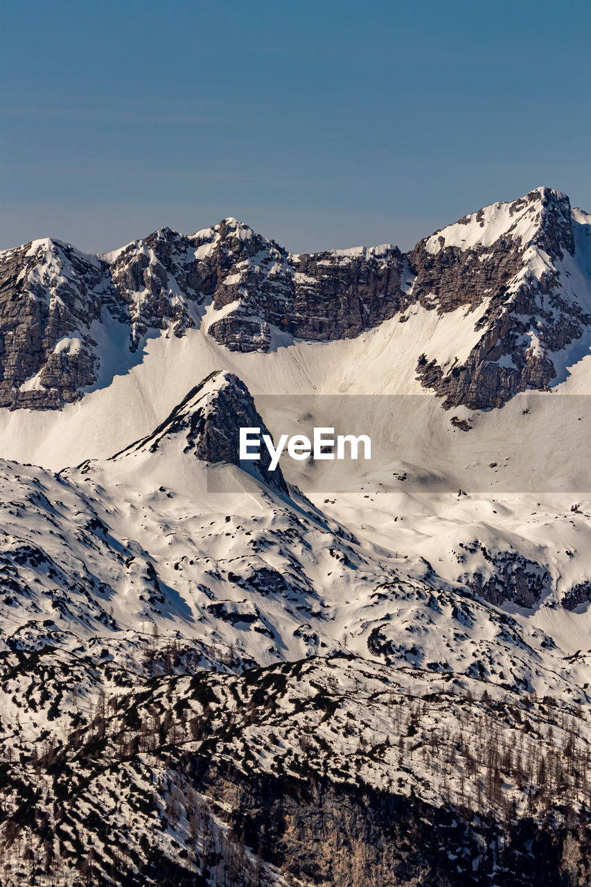 Scenic view of snowcapped mountains against clear sky