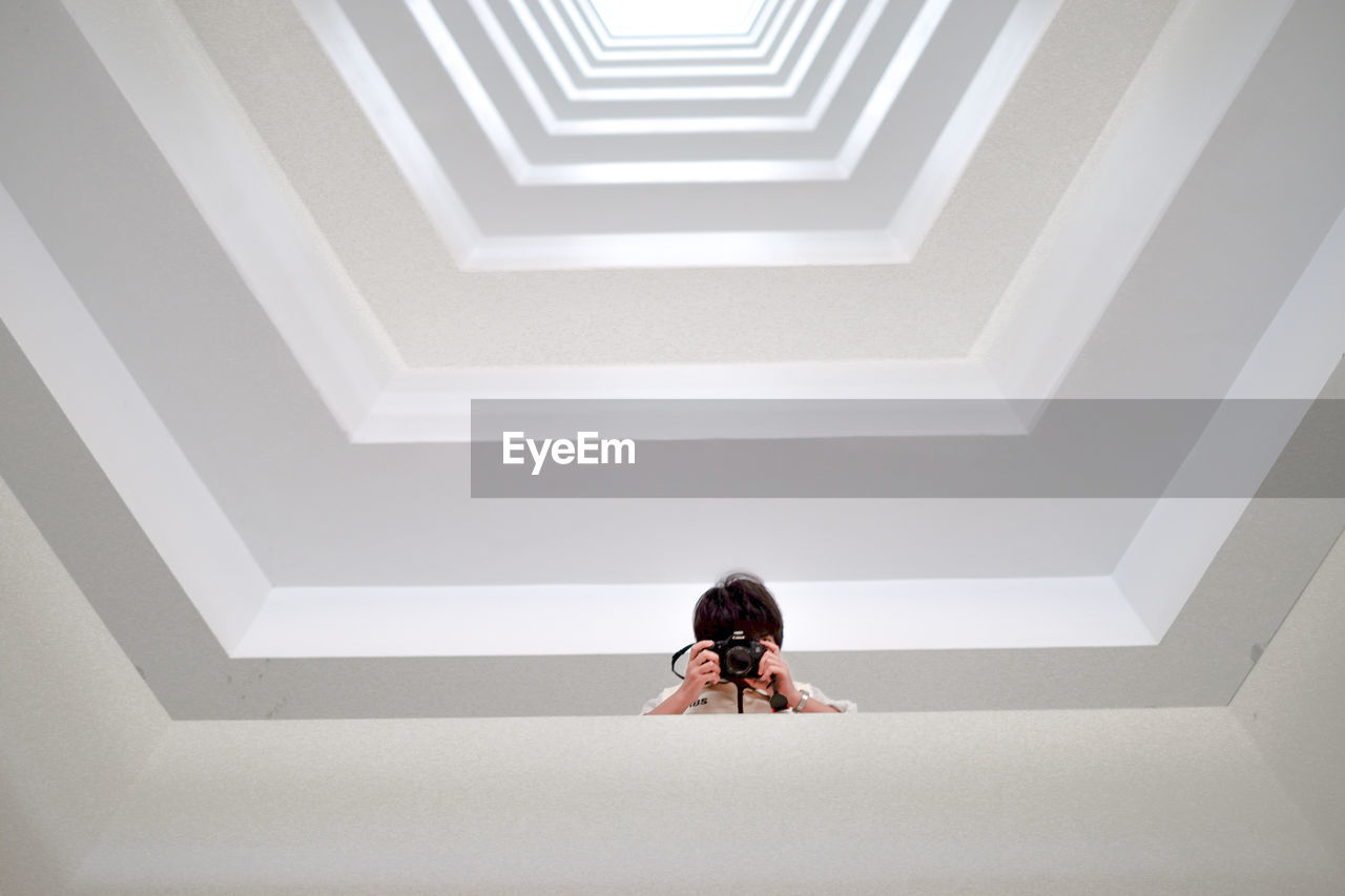 FULL LENGTH REAR VIEW OF WOMAN WALKING ON STAIRCASE