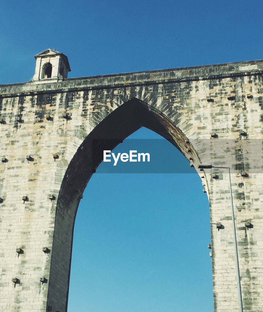 LOW ANGLE VIEW OF ARCH AGAINST CLEAR BLUE SKY