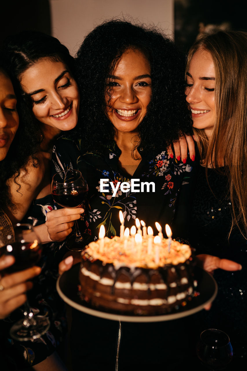 Young women looking at birthday cake