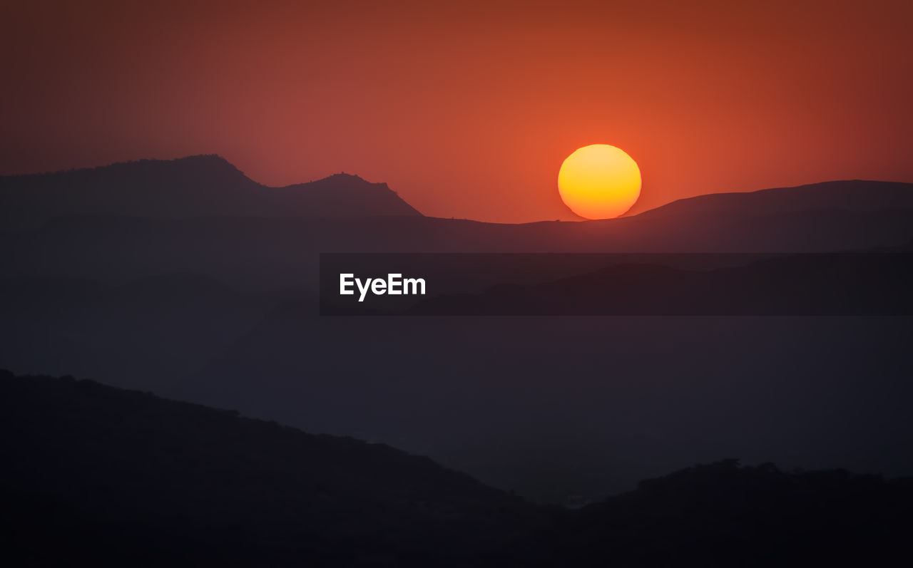 Scenic view of silhouette mountains against sky during sunset