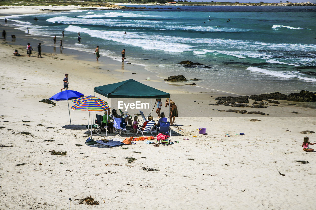 People at beach against sky