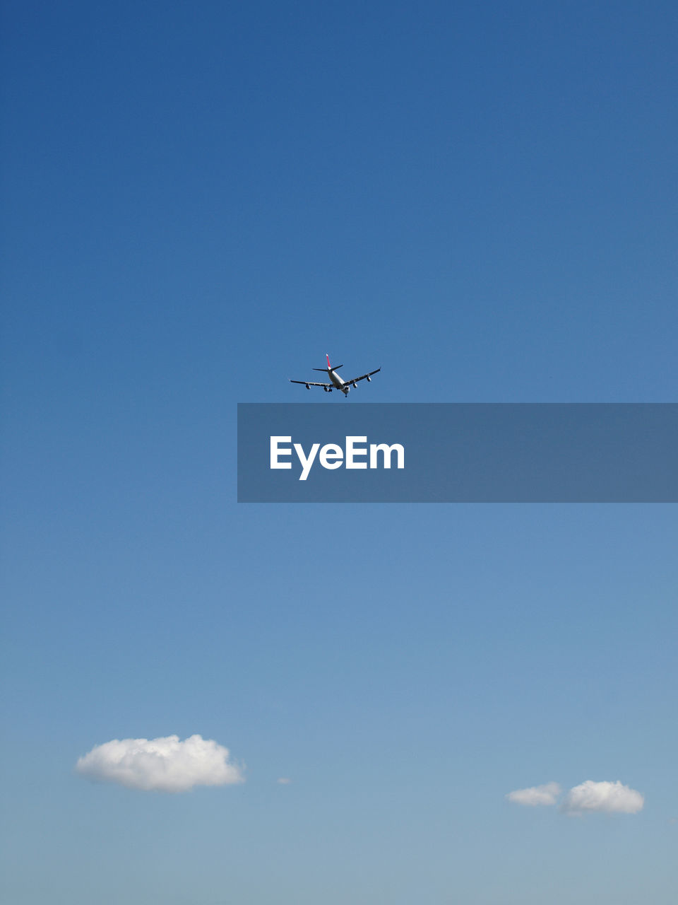 Low angle view of airplane flying in blue sky