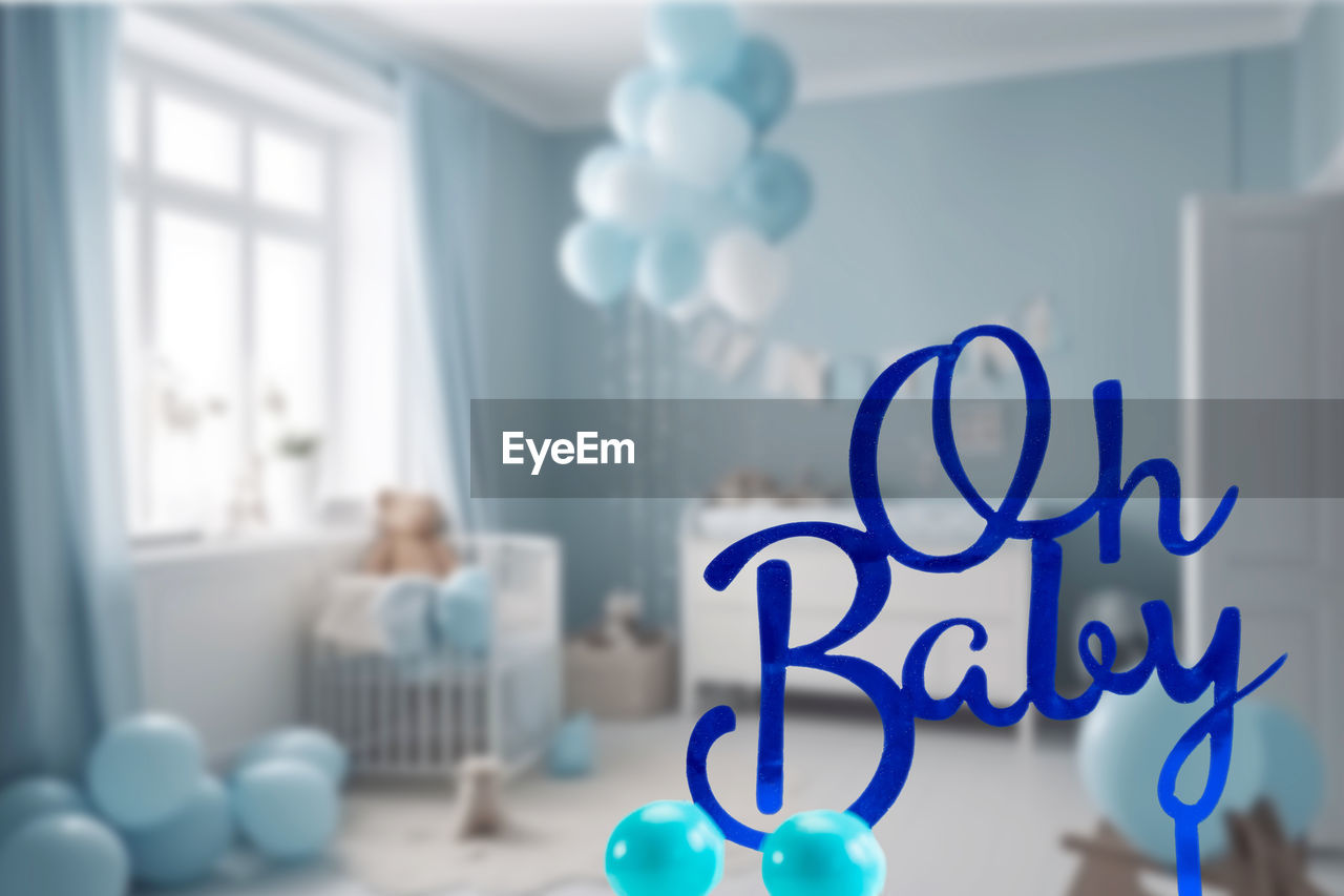 indoors, blue, window, domestic room, home interior, furniture, baby shower, domestic life, focus on foreground, day, communication, table, lifestyles, party, no people, living room